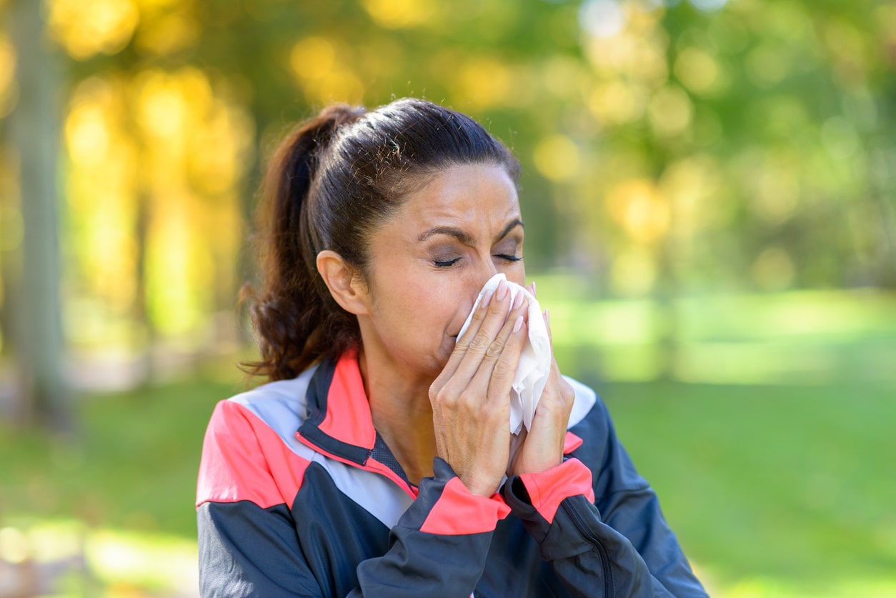 Woman blows nose while exercising