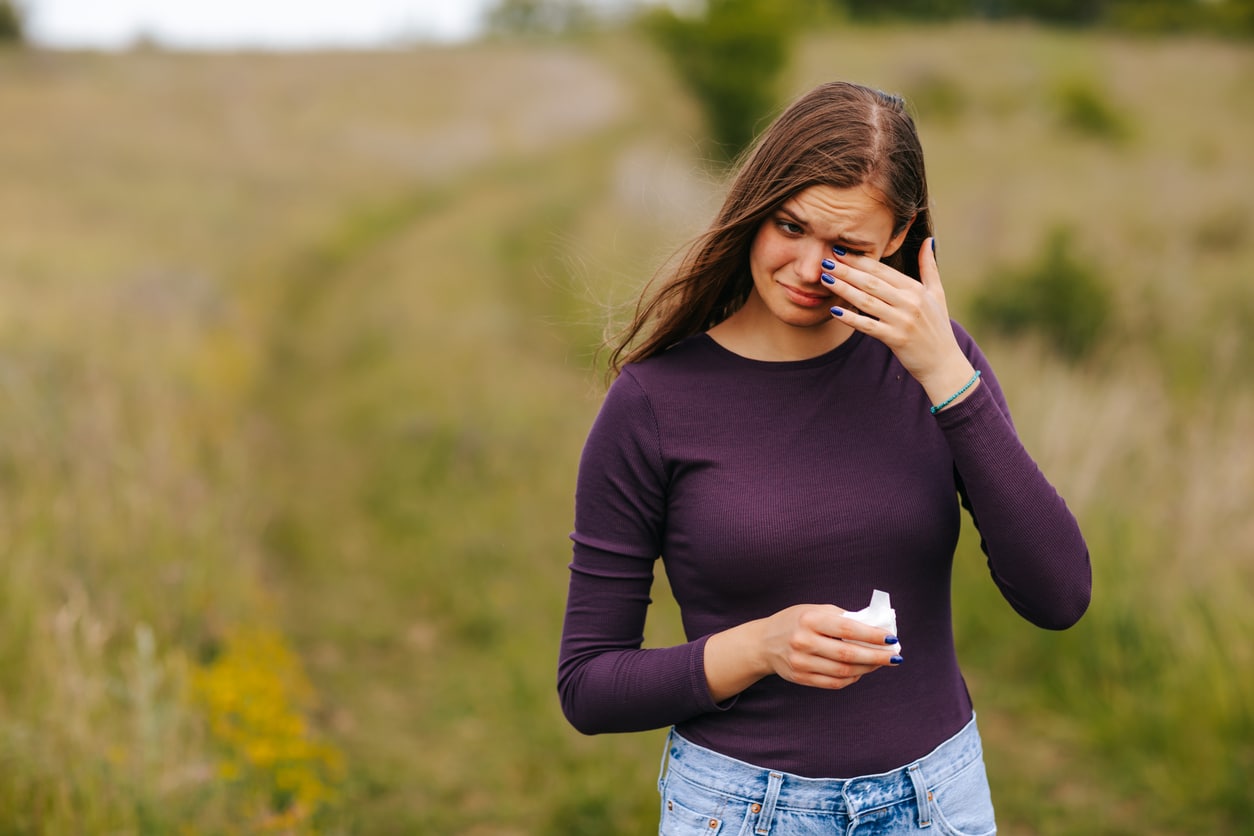 Woman with allergies rubs eyes