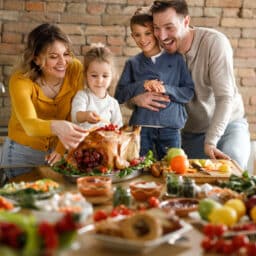 Family putting the finishing touches on their thanksgiving turkey