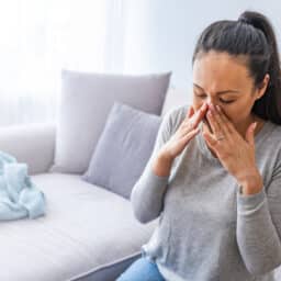 Woman with a sinus headache holding her nose